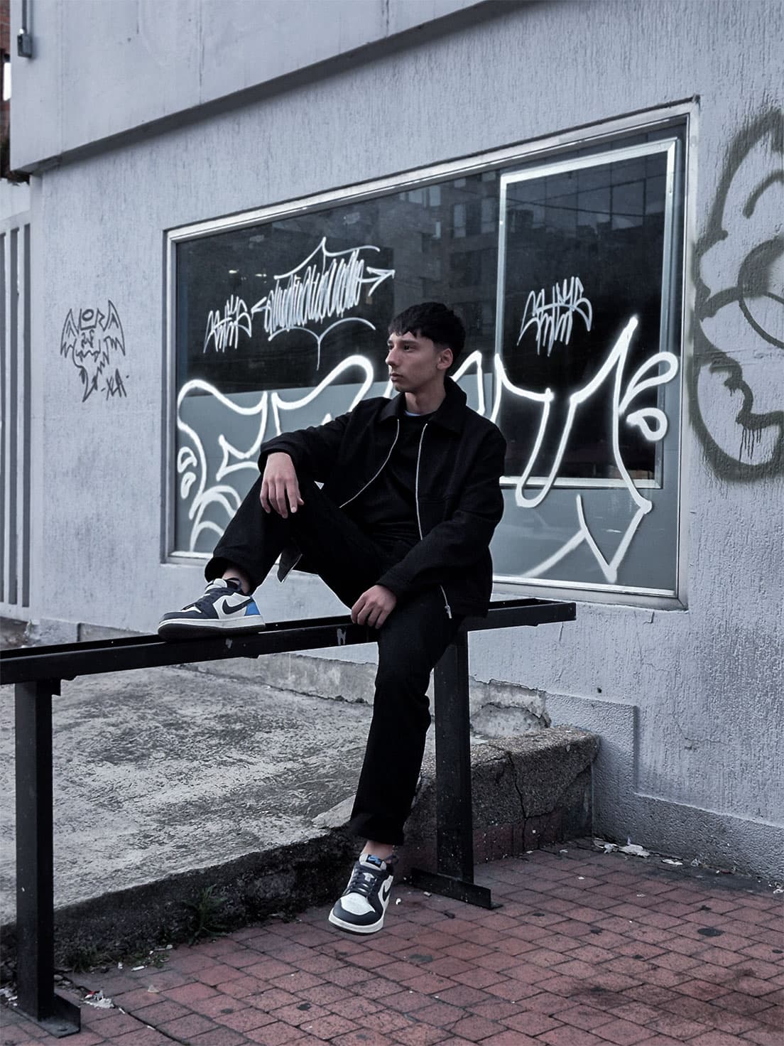ANDY EMBER seated in a street setting